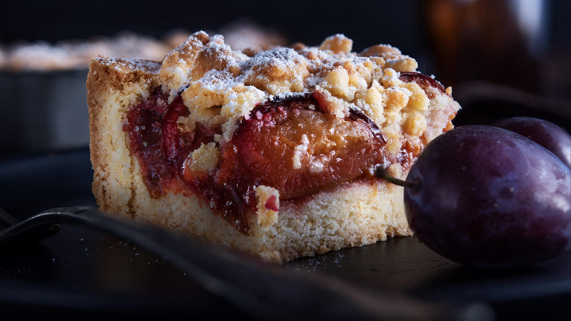 Pflaumenkuchen mit Streuseln: Wenn der Kuchen fertig und noch etwas warm ist, können Sie ihn nach Belieben mit Zucker bestreuen.