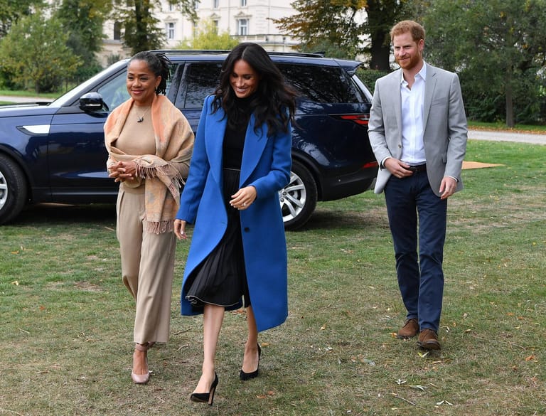 20. September 2018: In ihrem royalblauen Mantel und dem Kleid kaschiert die Herzogin von Sussex – in Begleitung von Mama Doria Ragland und Ehemann Prinz Harry – ihre Figur.