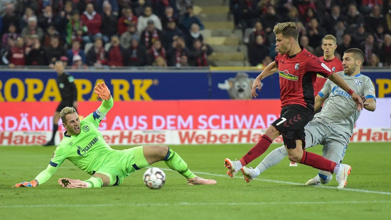 Schalkes Torwart Ralf Fährmann (l) kann den Schuss vom Freiburger Florian Niederlechner (r) nicht halten.