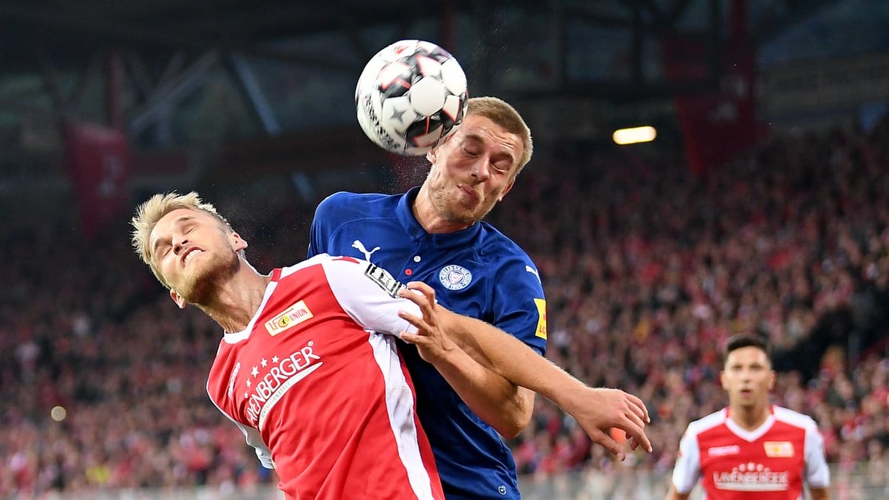 Unions Sebastian Andersson (l) und Kieler Hauke Wahl kämpfen um den Ball.