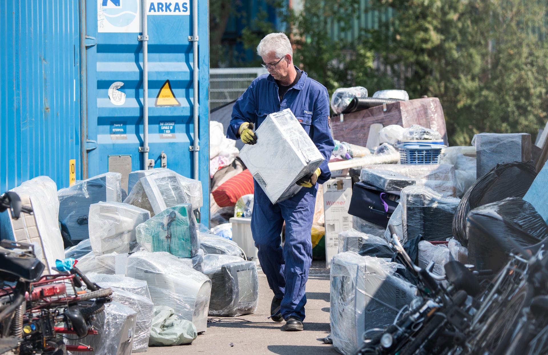 Polizeioberkommissar Wolfgang Heidorn, Wasserschutzpolizist, kontrolliert auf dem Gelände einer Spedition im Stadtteil Wilhelmsburg den Inhalt eines Containers. Es könnten darin Elektrogeräte versteckt sein, die nicht mehr funktionieren.