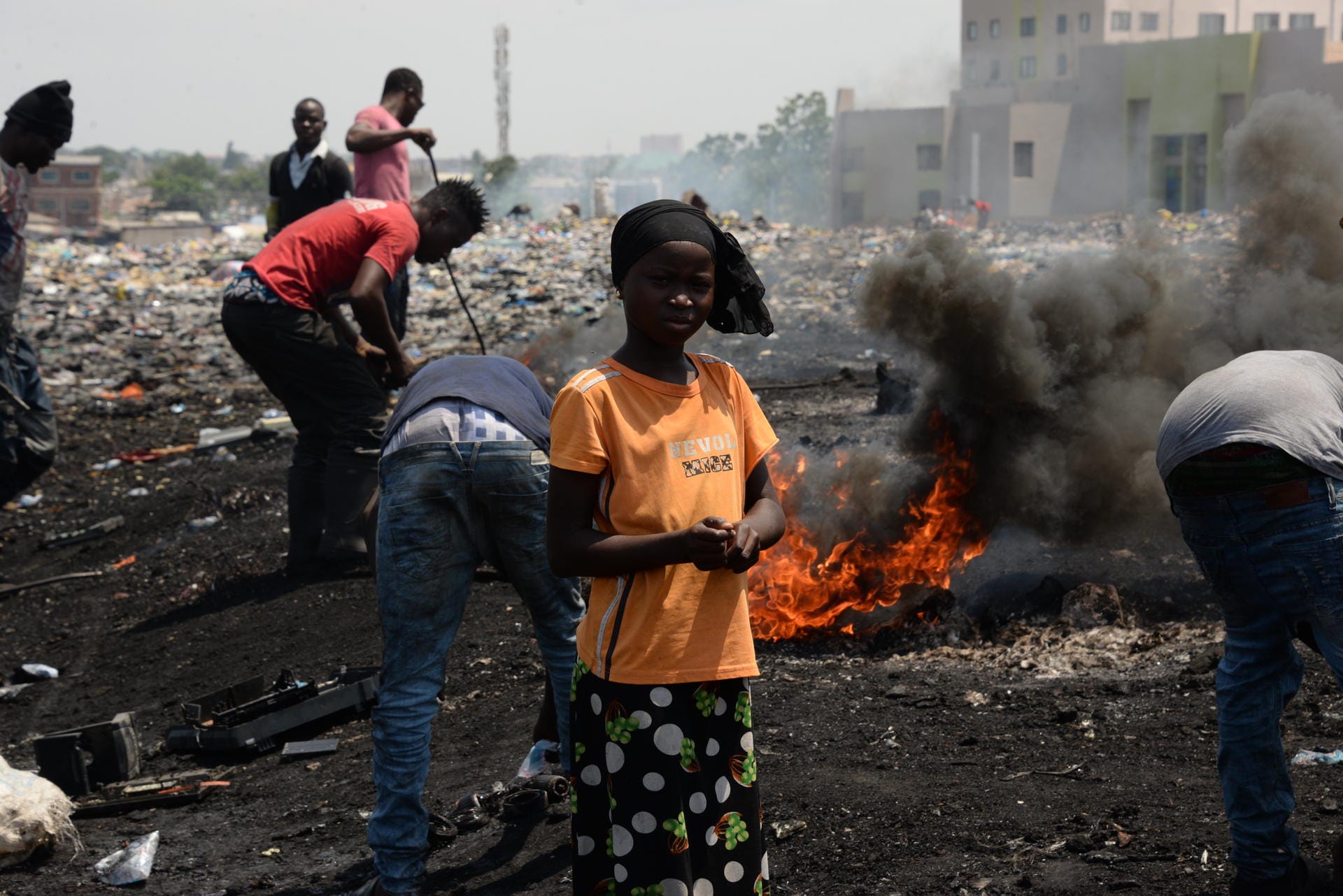 Ein Mädchen steht auf der Freifläche nahe des Schrottplatzes Agbogbloshie.