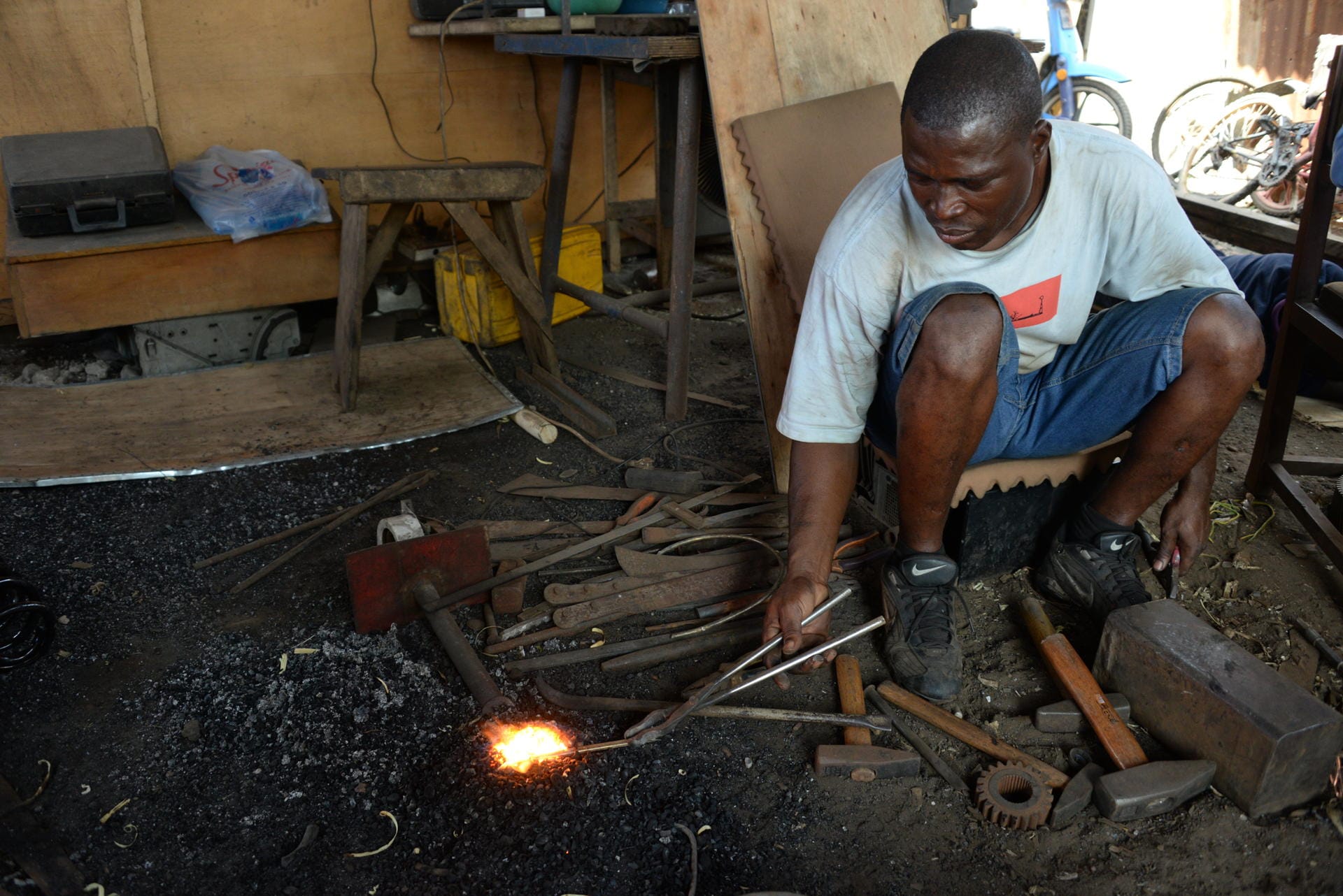 Der Recycler Olu Yahaya schmiedet aus Metallen, die er aus alten Elektrogeräten gewonnen hat, ein Armband.