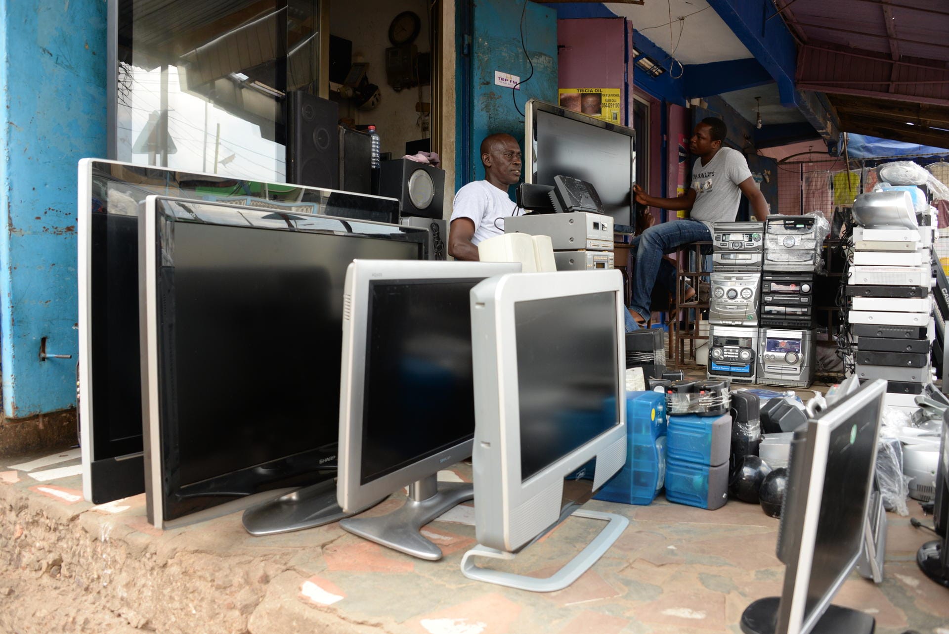 Vor dem Laden eines TV-Händlers in Accra stehen mehrere gebrauchte Fernseher. Die meisten davon wurden vor allem aus Großbritannien.