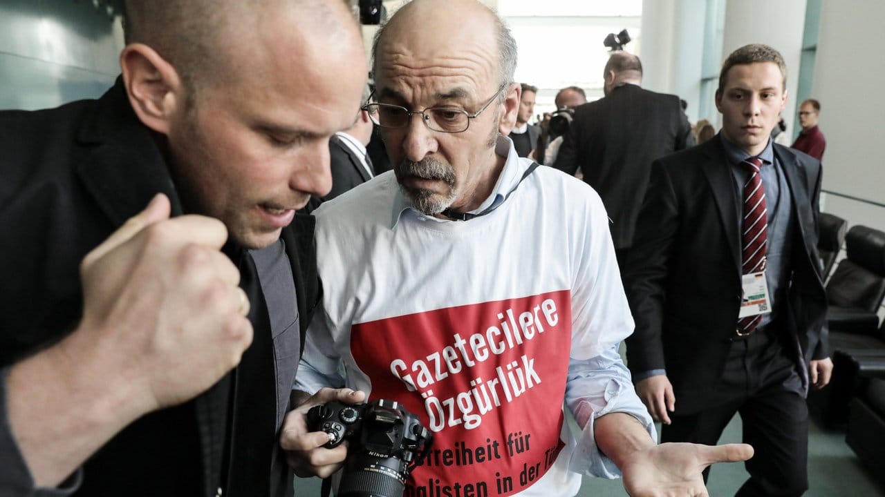 Ein Fotograf, der bei der gemeinsamen Pressekonferenz von Merkel und Erdogan im Bundeskanzleramt ein T-Shirt mit der Aufschrift "Pressefreiheit für Journalisten in der Türkei" trägt, wird aus dem Raum geleitet.