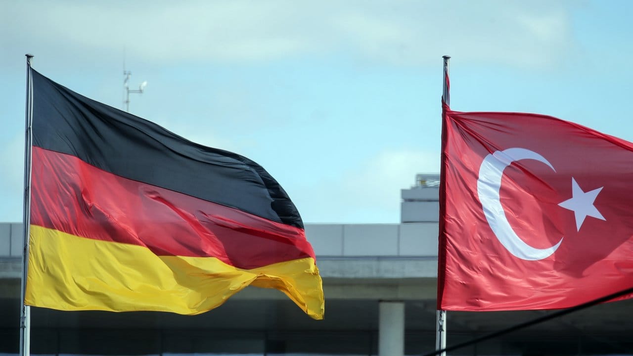 Eine deutsche und eine türkische Fahne wehen vor dem Bundeskanzleramt.