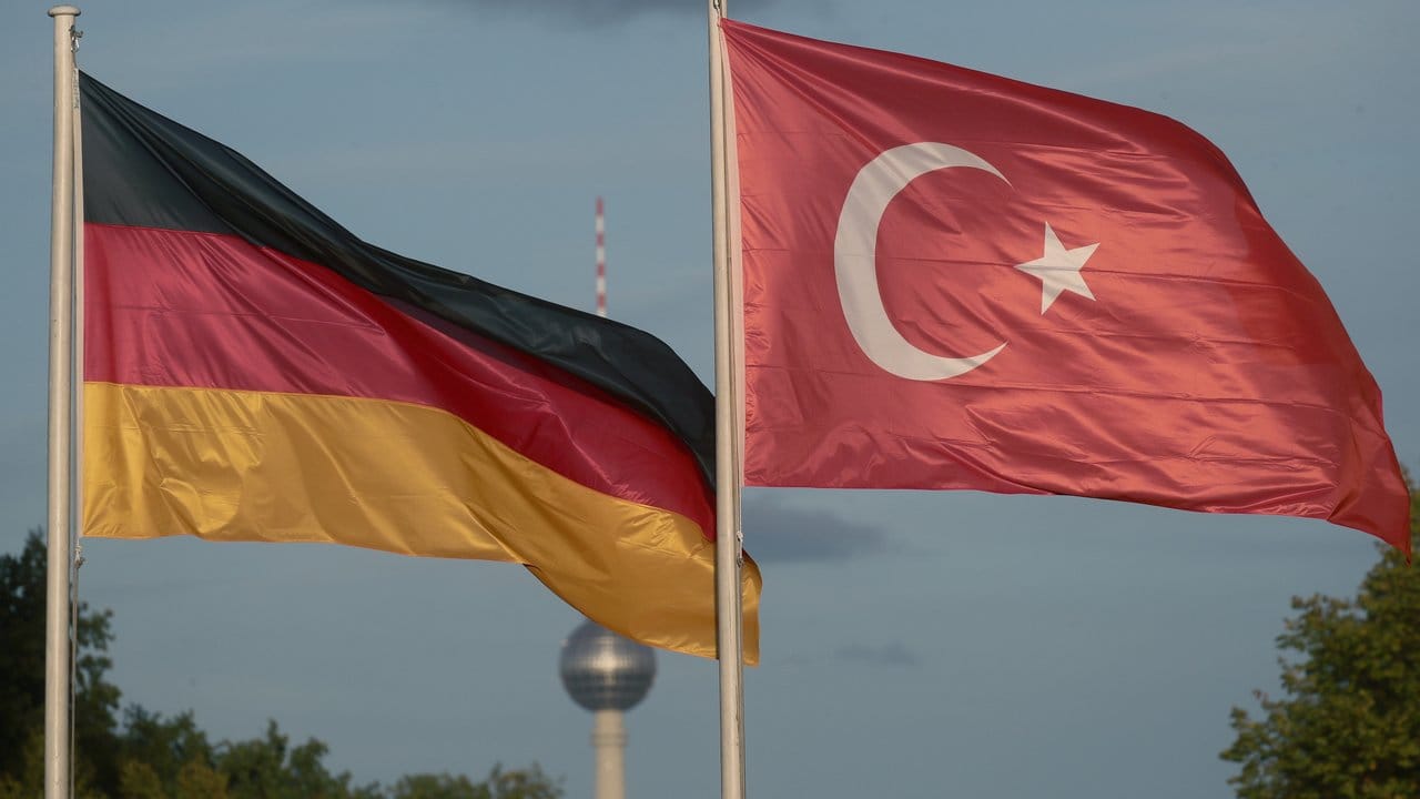 Eine deutsche und eine türkische Flagge wehen während des Besuchs des türkischen Präsidenten Erdogan in Berlin.
