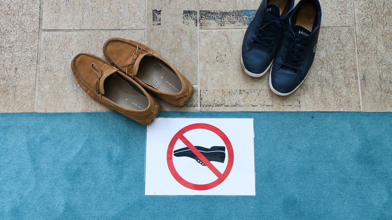 Ein Schild verbietet das Tragen von Schuhen.