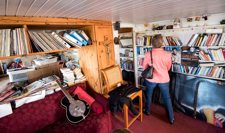 Zahlreiche Bücher und Schallplatten: Eine Frau schaut ein Zimmer auf dem Hausboot an.