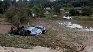 Zerstörte Autos mitten auf einem Feld: Starker Regen und Sturzfluten haben auf der Urlaubsinsel Mallorca verheerende Schäden angerichtet.