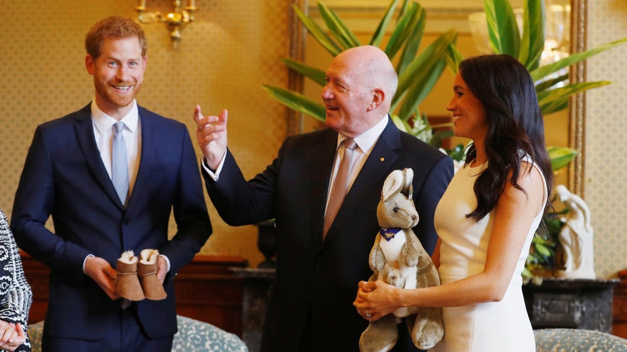 Erste Gastgeschenke: Sir Peter Cosgrove übereicht Harry und Meghan ein Plüsch-Känguru und ein Paar der typischen australischen Lammfell-Stiefel (Ugg Boots) in kleinster Kindergröße.