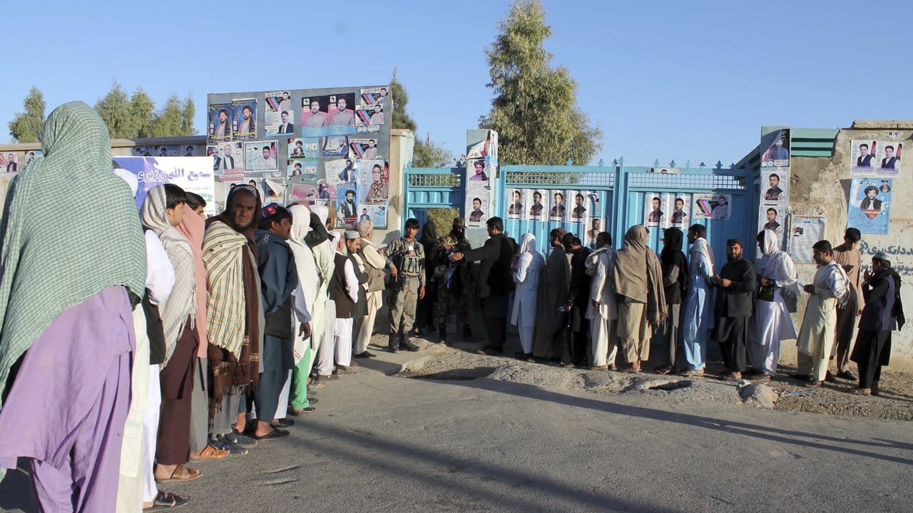 Afghanische Männer und Frauen warten vor einem Wahllokal in Helmand, um ihre Stimme abzugeben. Afghanische Männer und Frauen warten vor einem Wahllokal in Helmand, um ihre Stimme abzugeben.