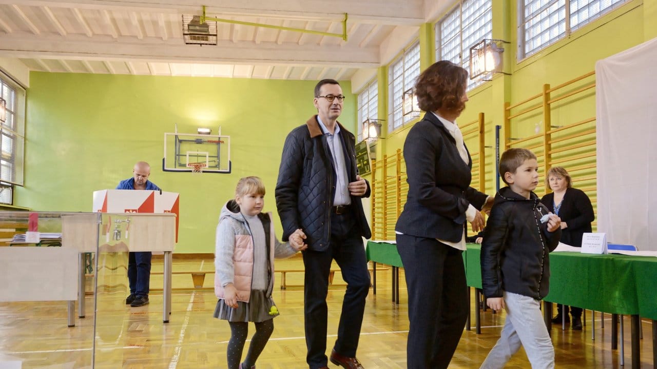 Mateusz Morawiecki, Premierminister von Polen, seine Frau Iwona und seine Kinder bei der Stimmabgabe in einer Turnhalle.