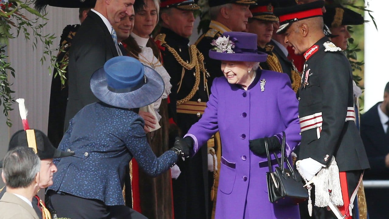 Theresa May (l), in Blau, Königin Elizabeth II.