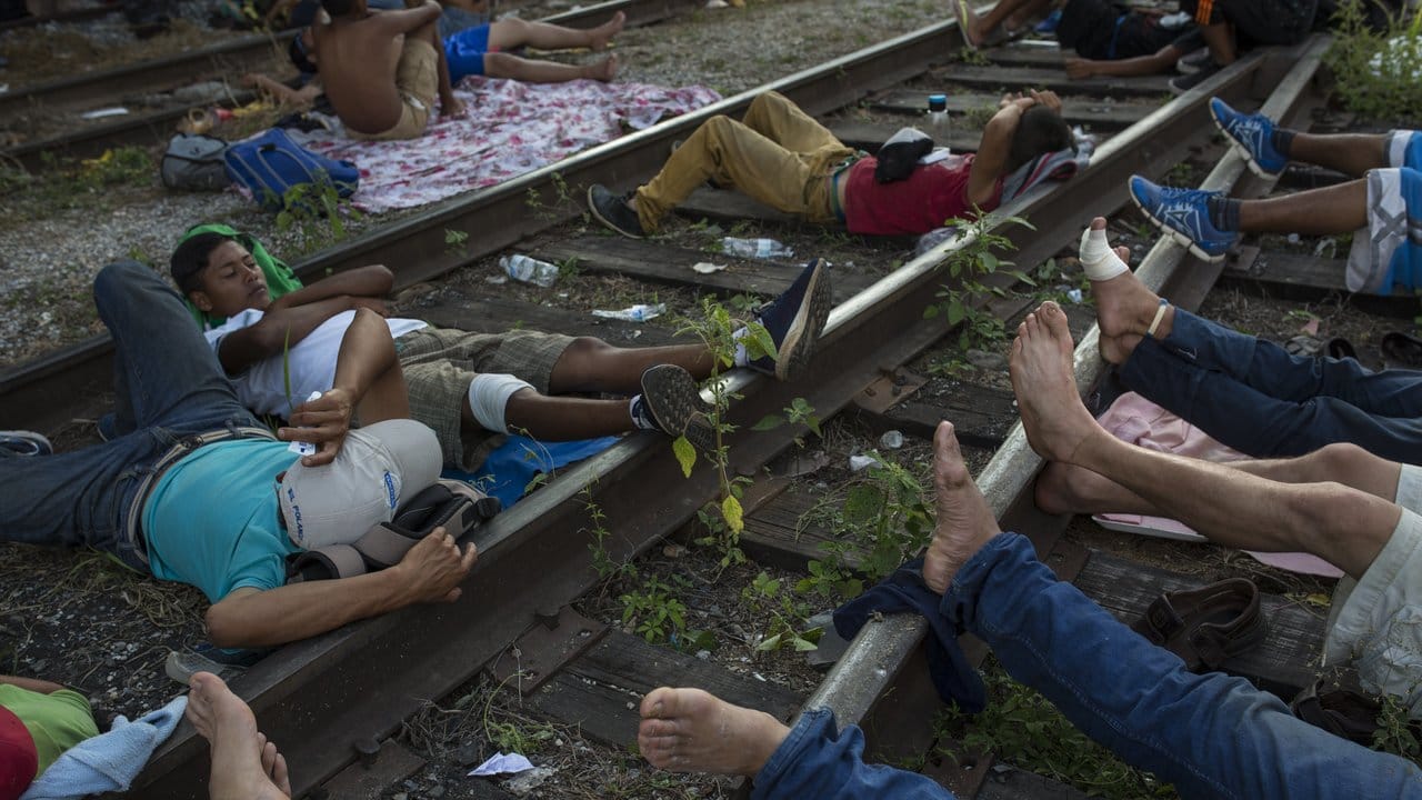 Mittelamerikanische Migranten ruhen sich auf den Eisenbahnschienen aus, bevor sie weiter Richtung US-Grenze reisen.