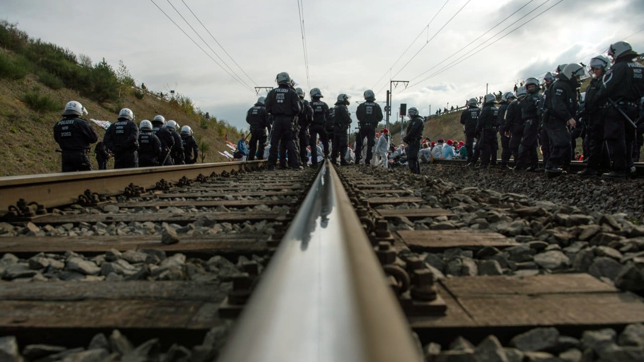 Aktivisten des Aktionsbündnisses "Ende Gelände" sitzen auf den Gleisen der Kohlebahn.