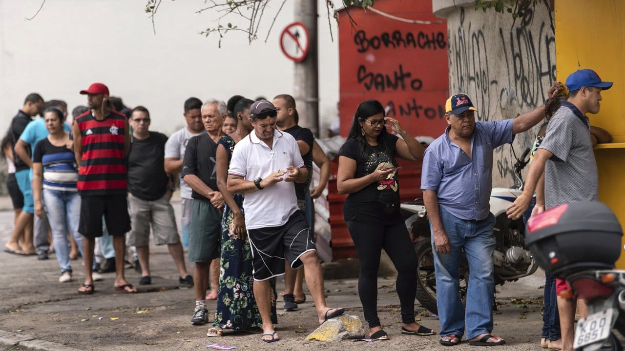 Menschen stehen vor einem Wahllokal in Rio de Janeiro Schlange um ihre Stimme für die Präsidentschaftswahlen abzugeben.