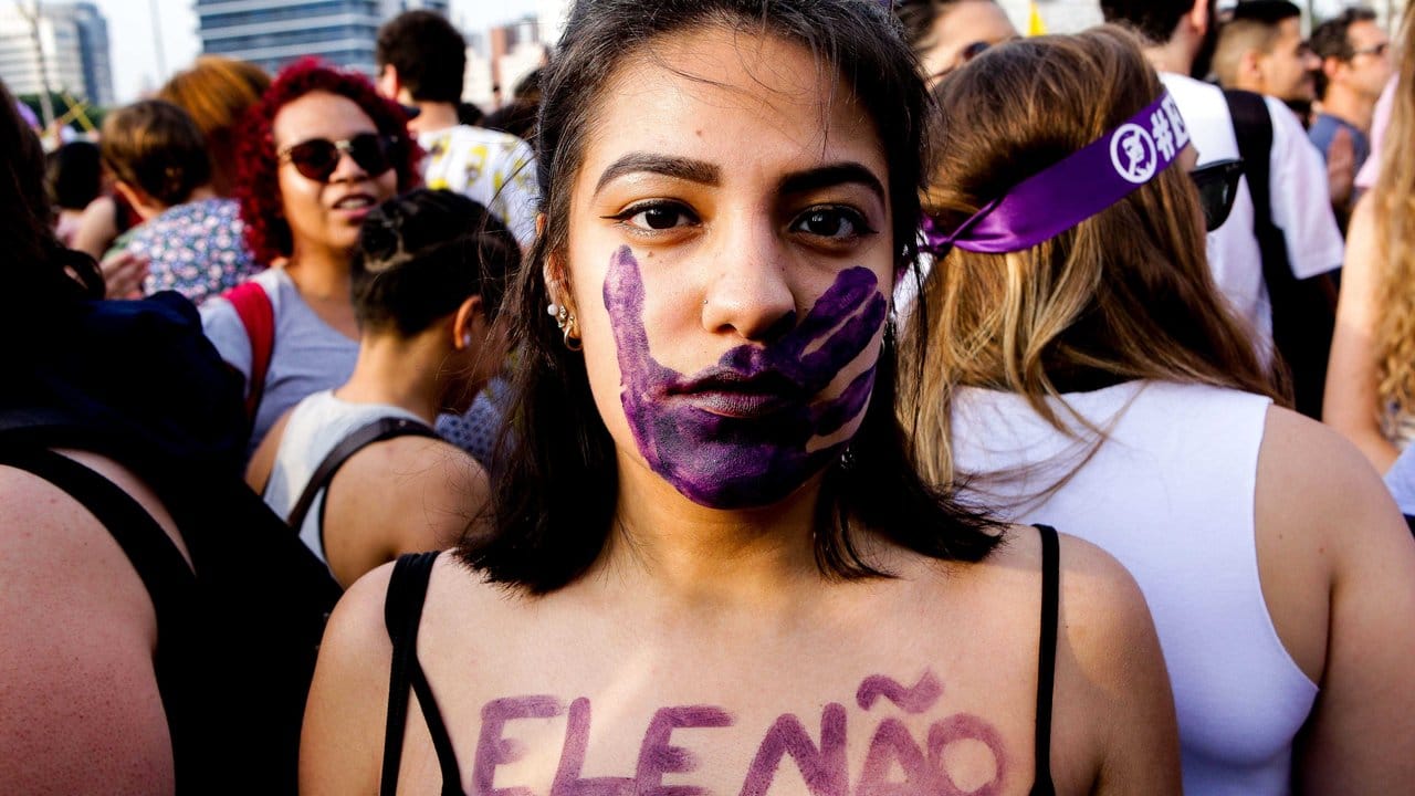 Eine Frau hat sich "Ele nao" (auf Deutsch "er nicht") auf den Körper geschminkt.