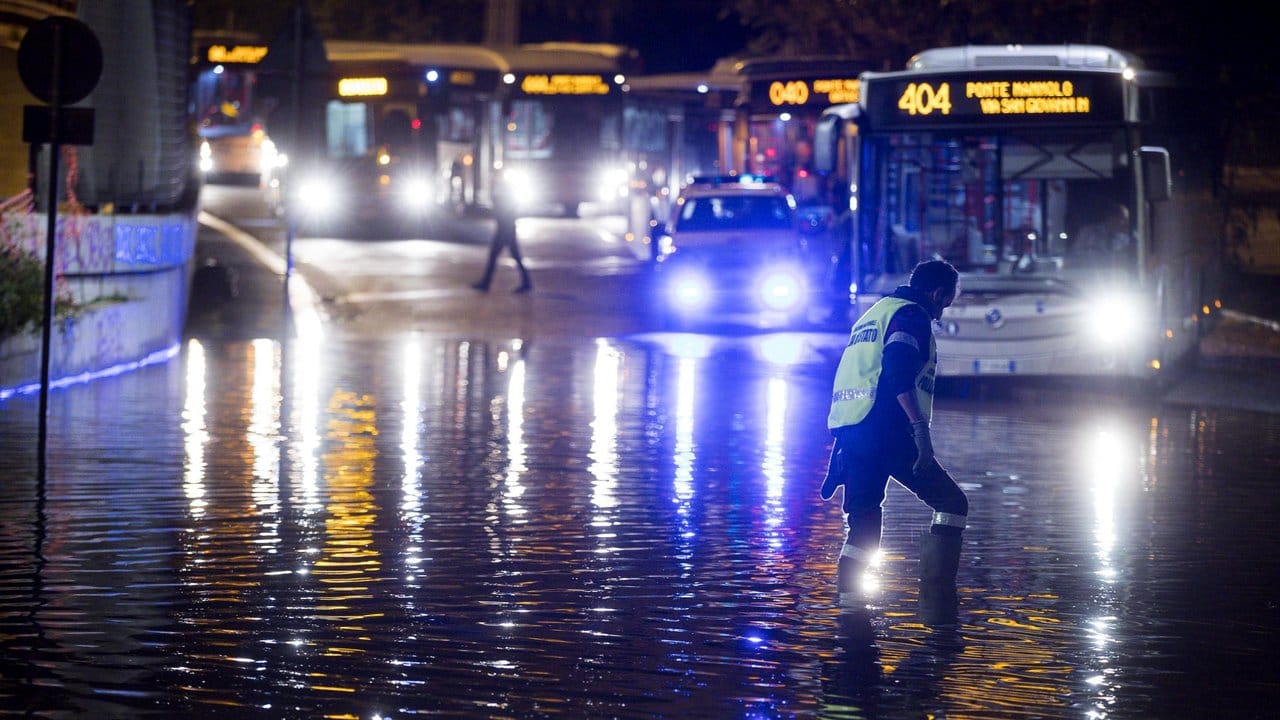 Busse stehen in Rom auf einer überfluteten Straße.