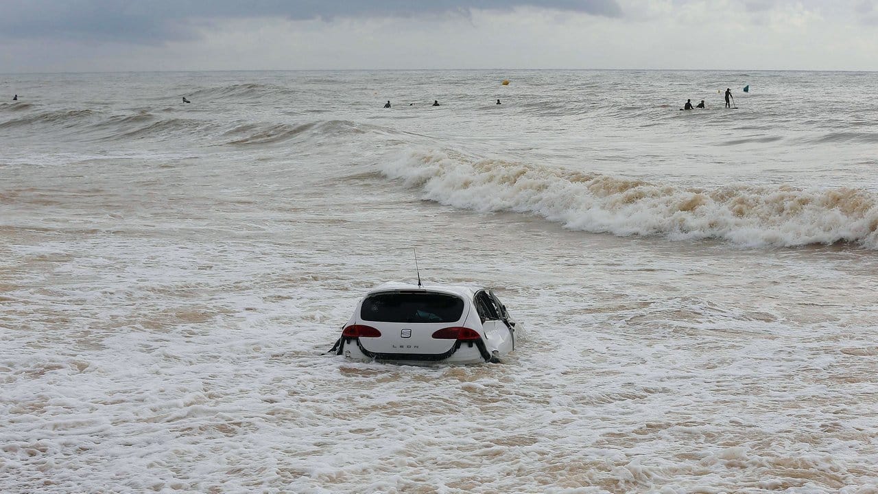 Wellen prallen gegen ein Auto, das am Vortag nach einem Sturm ins Wasser geschleudert wurde.