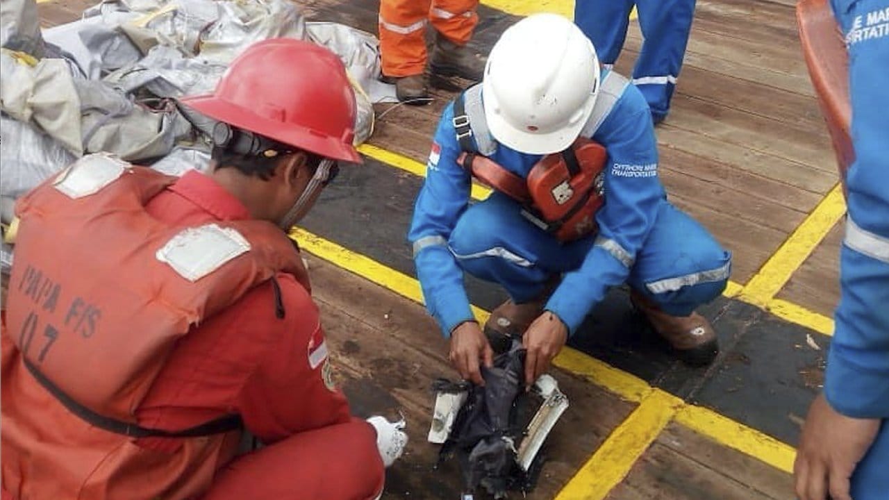 Rettungskräfte untersuchen Trümmerteile vor West Java.