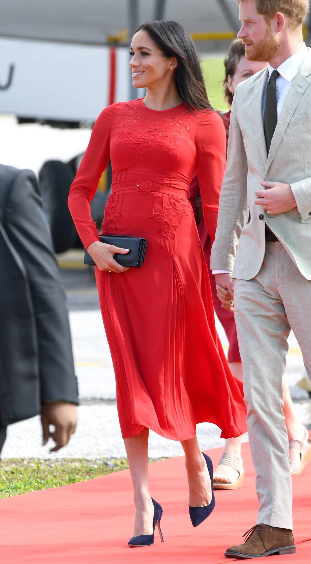Später am Tag kommt das royale Paar in Tonga an: Meghan führt ein rotes luftiges Kleid von Self-Portrait aus.