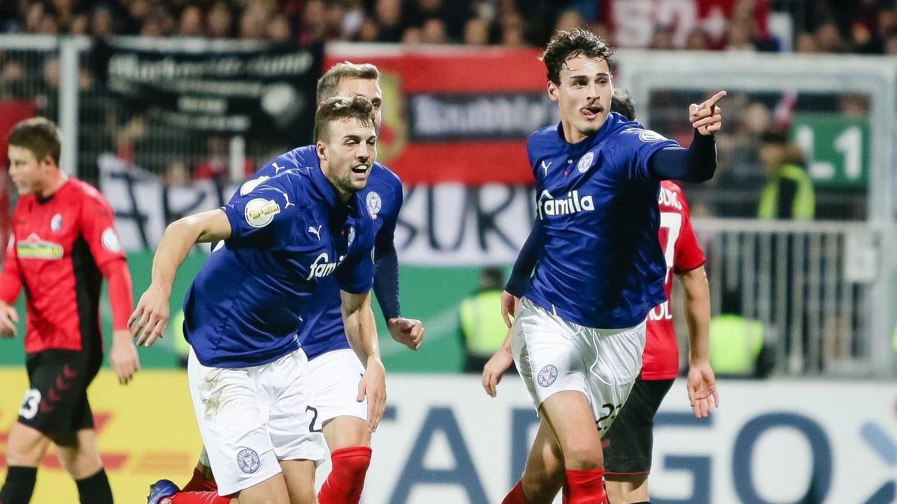Die Kieler Jonas Meffert (l-r) und Janni Serra feiern dessen Tor gegen Freiburg. Die Kieler Jonas Meffert (l-r) und Janni Serra feiern dessen Tor gegen Freiburg.