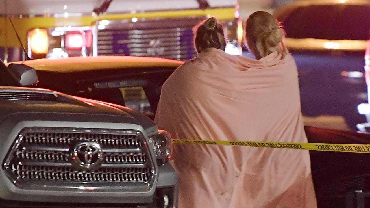 Eingehüllt in eine Decke, verlassen zwei Frauen den Tatort in Thousand Oaks.