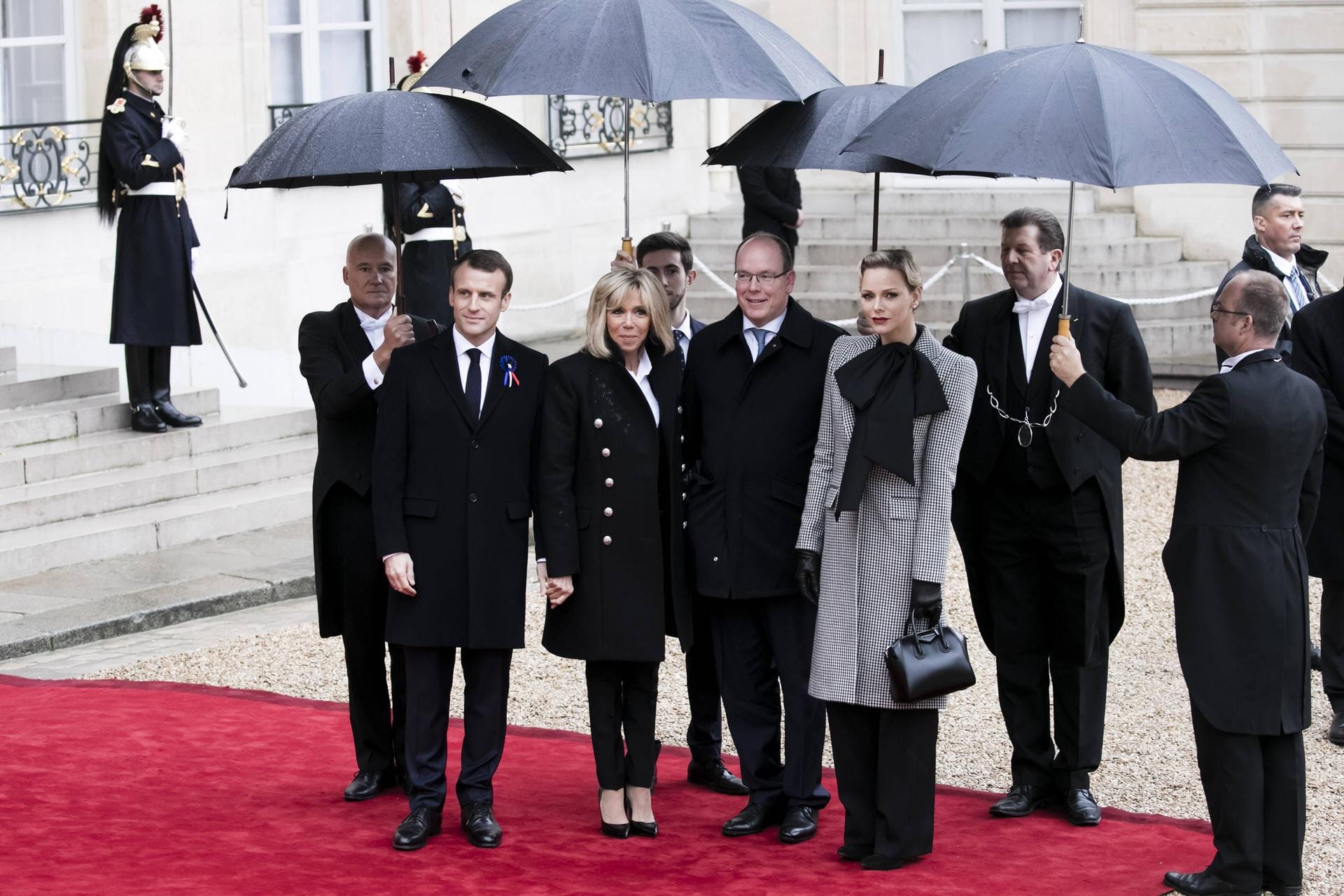 Schutz vor dem Regen: Brigitte und Emmanuel Macron posieren mit Fürst Albert und Fürstin Charlène.