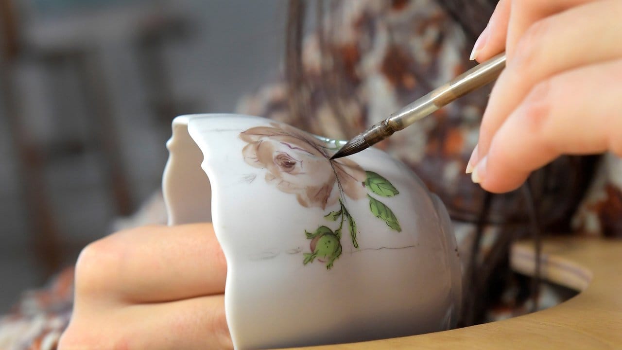 Ein filigranes Blumenmuster entsteht auf einer Tasse: Für ihre Arbeit brauchen angehende Manufakturporzellanmaler eine absolut ruhige Hand.