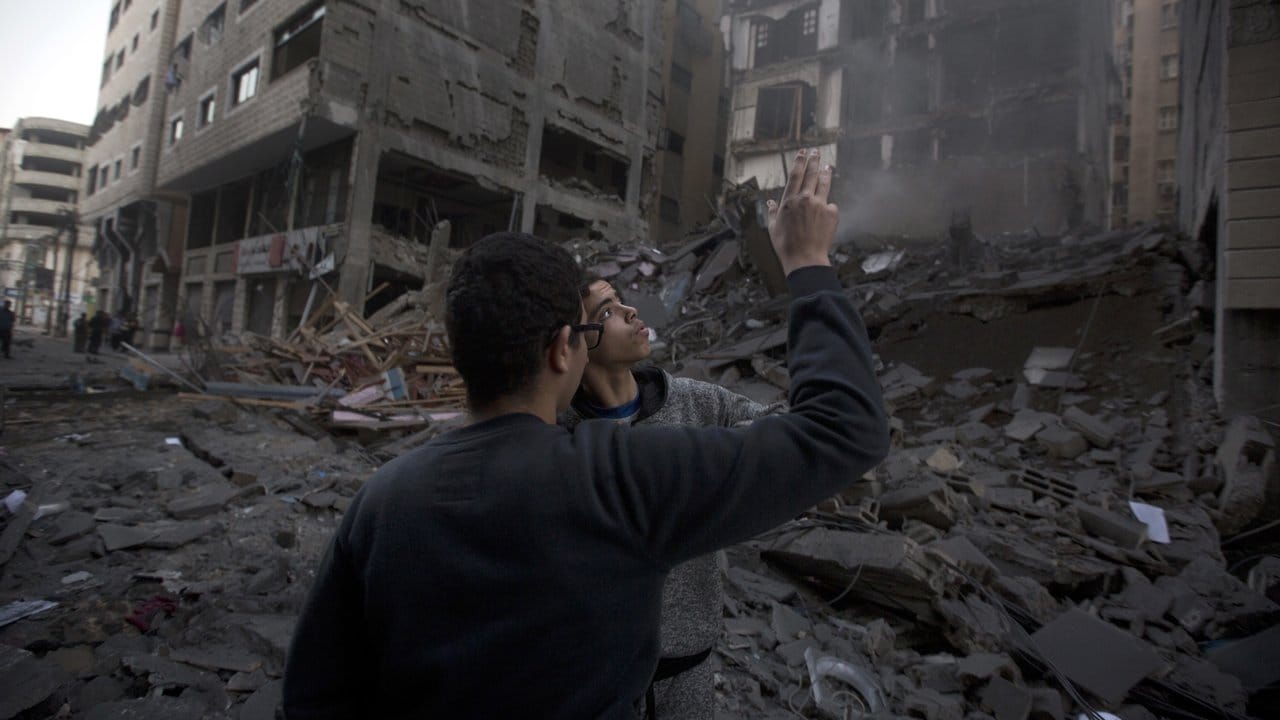 Palästinenser vor einem zerstörten Wohngebäude in Gaza-Stadt.