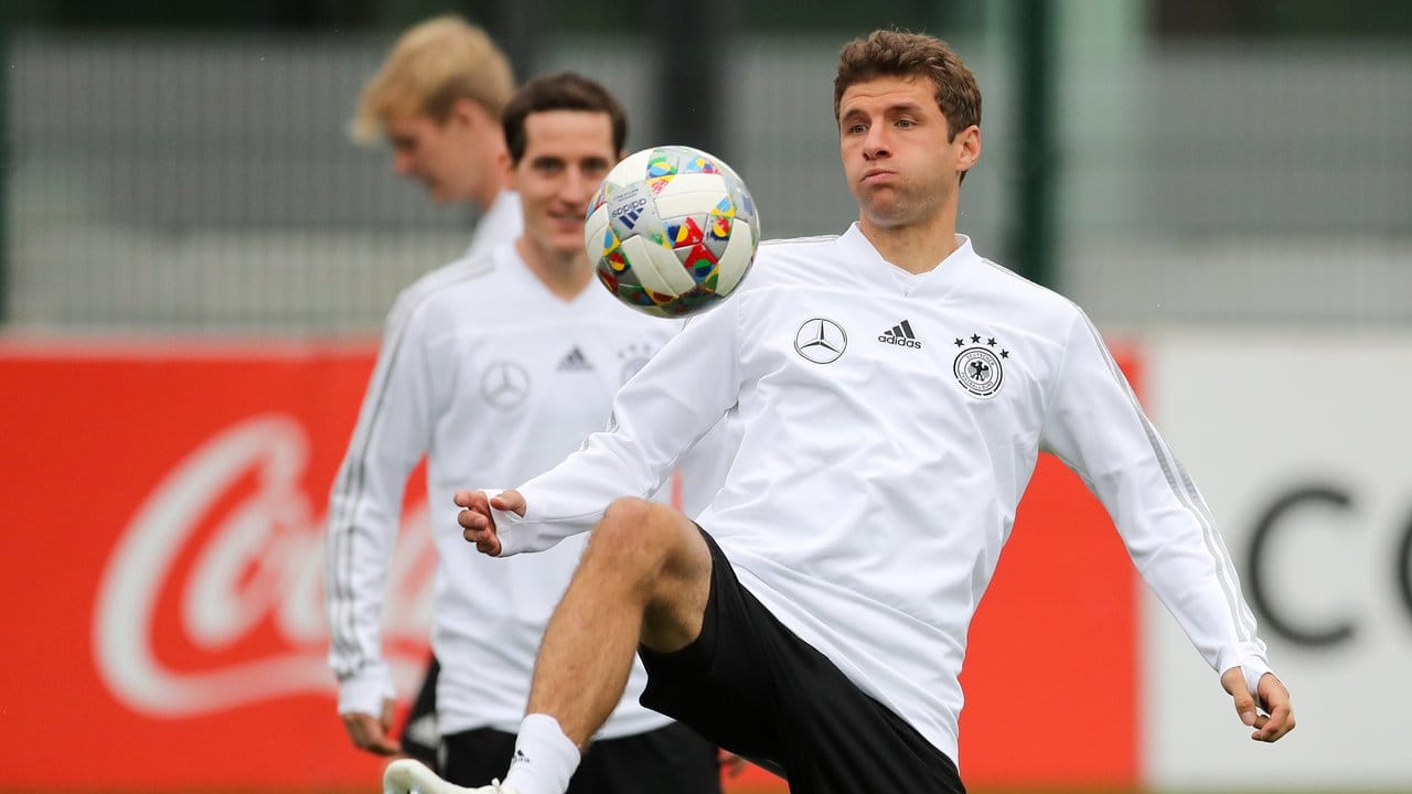 Thomas Müller hält den Ball hoch.