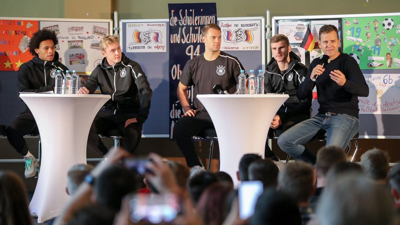 Teammanager Oliver Bierhoff (r) bei einer Pressekonferenz des DFB-Teams vor Schülern.