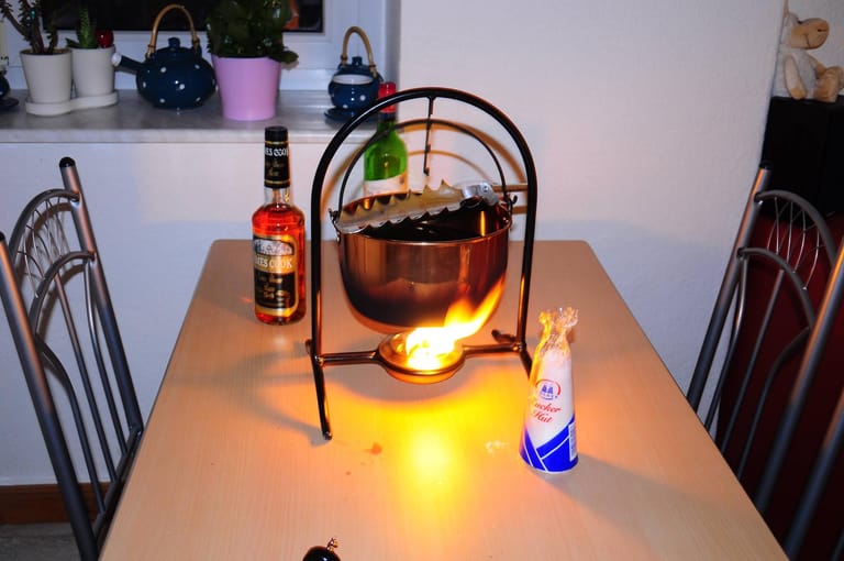 Traditionell wird für die Feuerzangenbowle ein großer Kupferkessel, eine Feuerzange, Rotwein, Rum, Orangensaft, Gewürze und ein Zuckerhut benötigt.