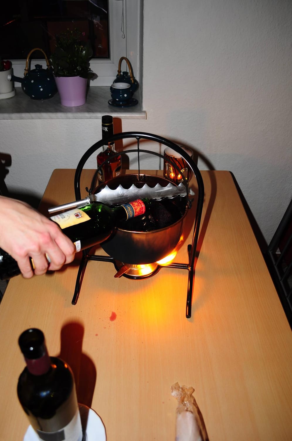 Zuerst werden der Rotwein, der Orangensaft und die Gewürze in den Topf gegeben und das Ganze wird erhitzt, ohne die Flüssigkeit aufkochen zu lassen.