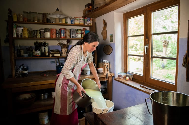 Lina Schimmel schüttet in der Küche des Hofes die sogenannte Dickete mit der Molke in ein Seihtuch.