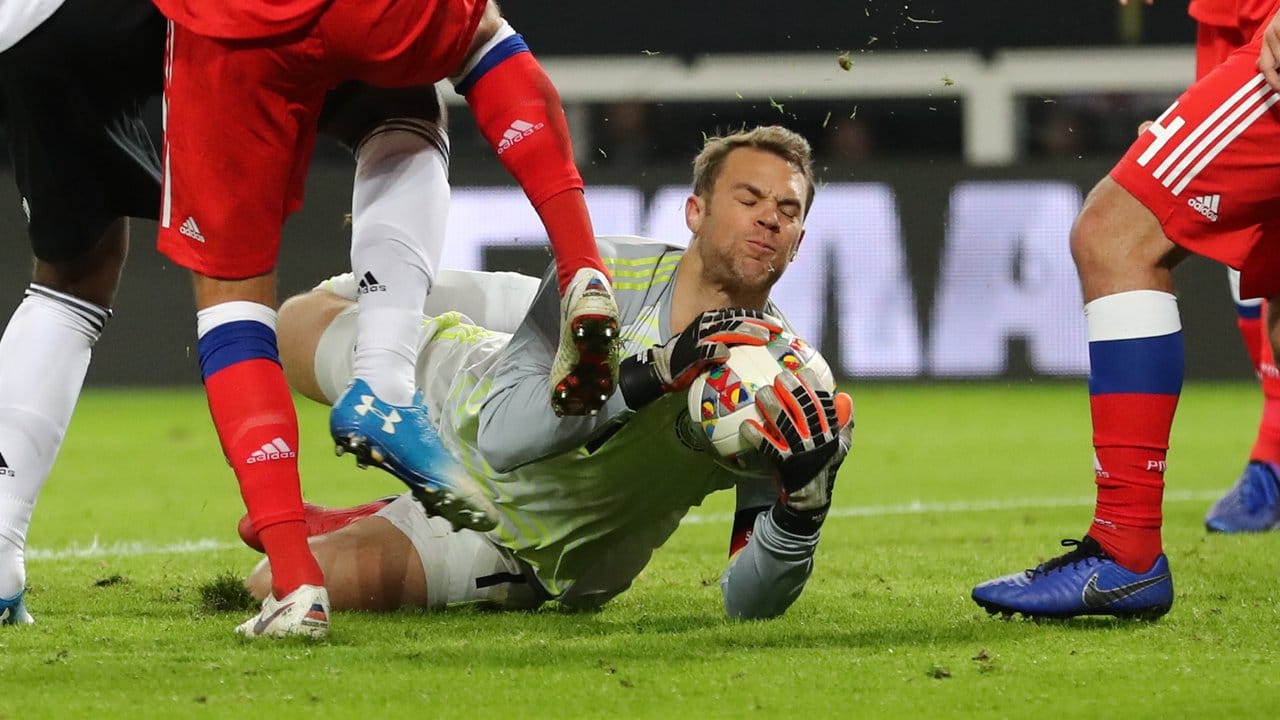 Torwart Manuel Neuer sichert den Ball vor zwei heranstürmenden Russen.