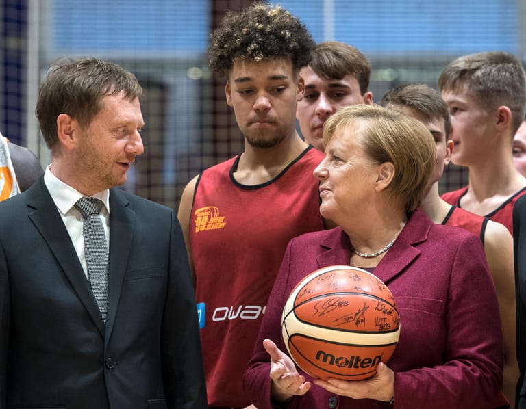 Zu Besuch in Chemnitz: Kanzlerin Angela Merkel und Sachsens Ministerpräsident Michael Kretschmer (beide CDU) mit jungen Basketballern von Chemnitz 99.