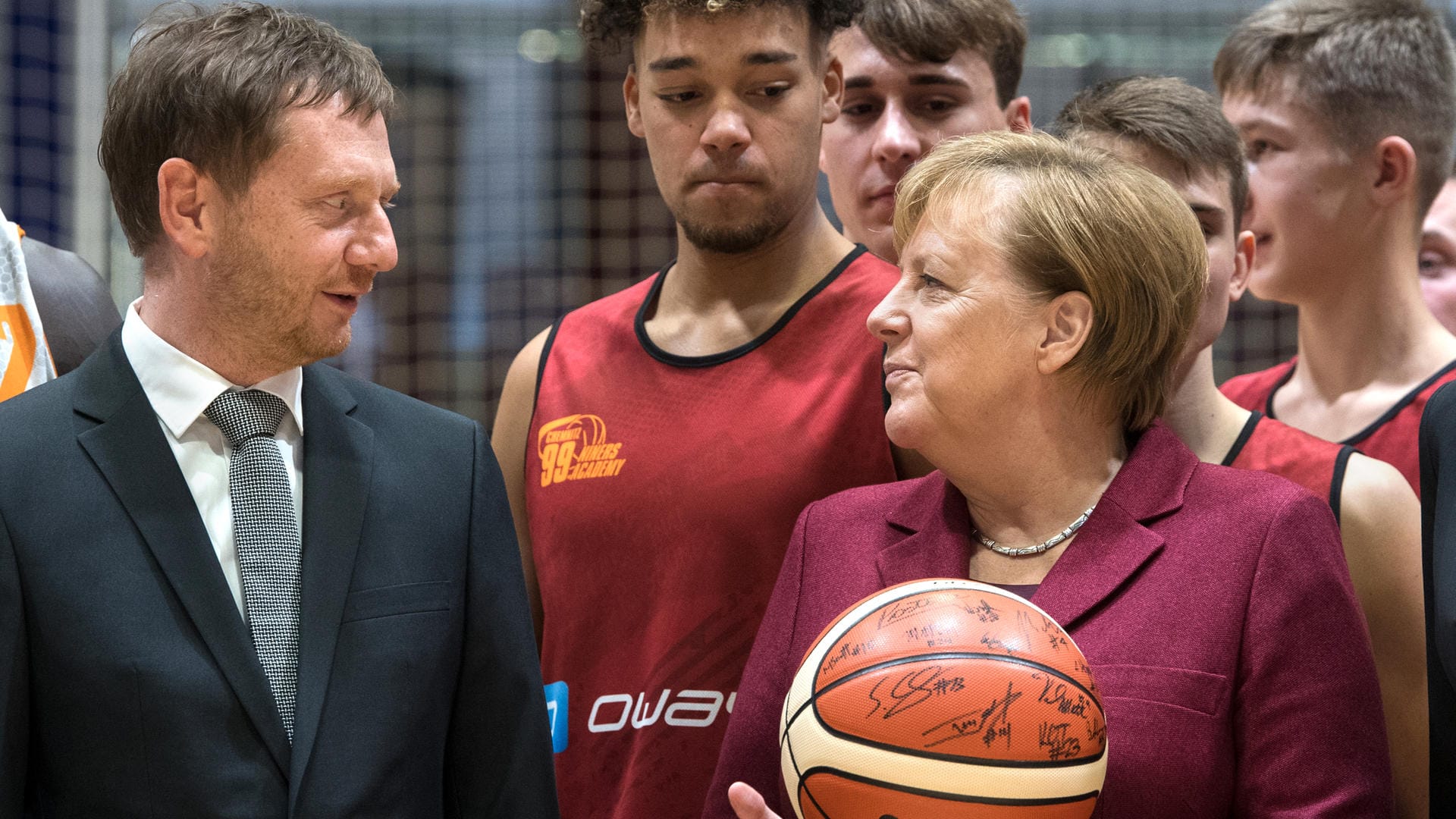 Zu Besuch in Chemnitz: Kanzlerin Angela Merkel und Sachsens Ministerpräsident Michael Kretschmer (beide CDU) mit jungen Basketballern von Chemnitz 99.