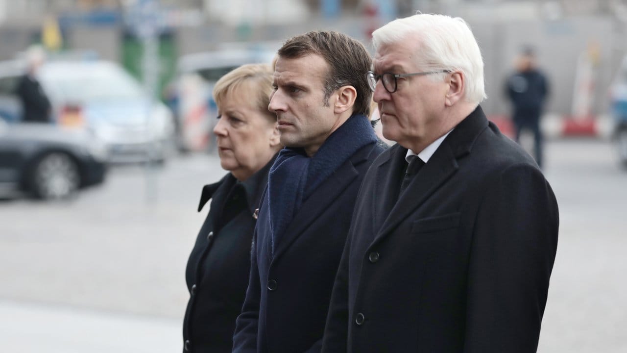 Frankreichs Präsident Emmanuel Macron kommt mit Bundeskanzlerin Angela Merkel und Bundespräsident Frank-Walter Steinmeier zur Kranzniederlegung.