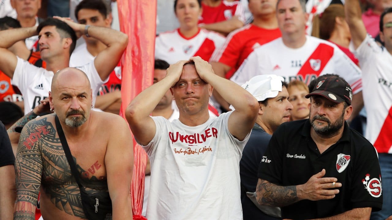 Fans von River Plate zeigen sich nach langem Warten in der Sonne enttäuscht, nachdem das Finale verlegt worden ist.