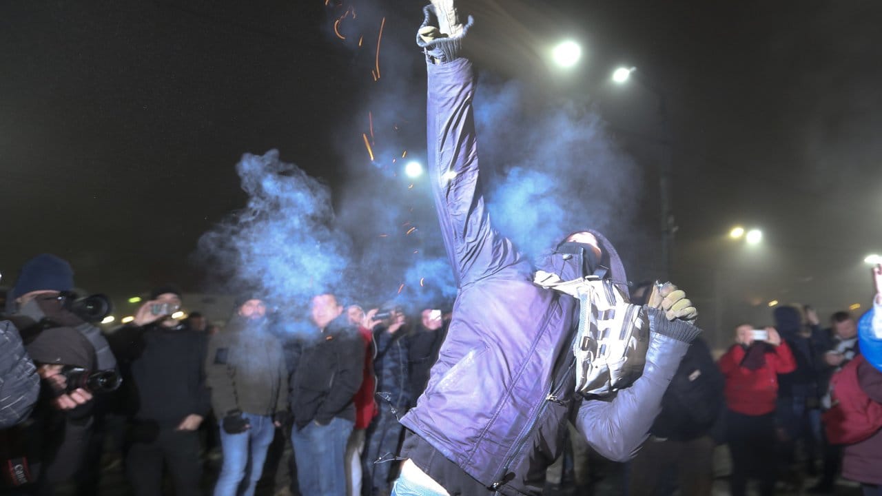 Ein Demonstrant wirft eine Rauchgranate während einer Demonstration vor der russischen Botschaft in Kiew.