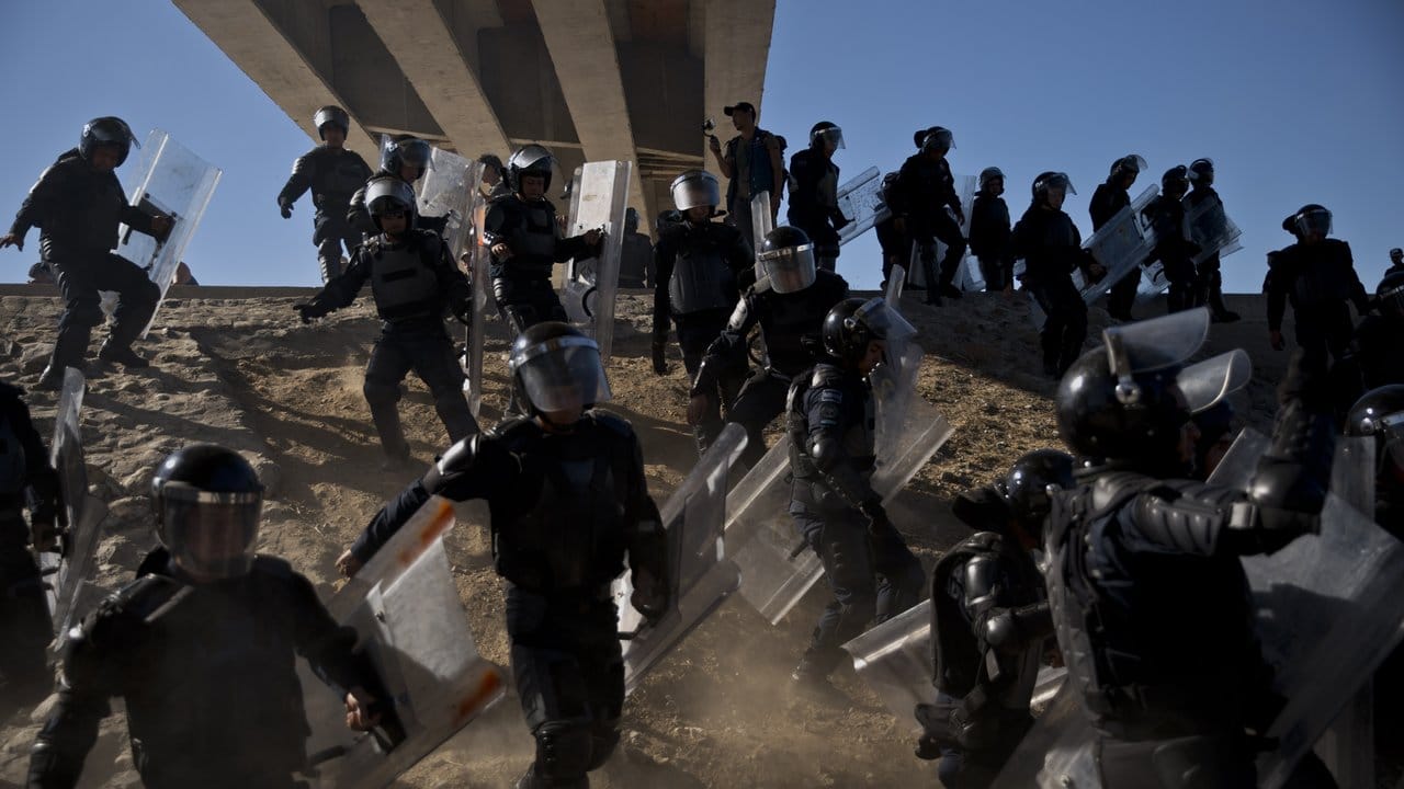 Mexikanische Polizisten versuchen Migranten davon abzuhalten, den Grenzübergang El Chaparral zu den USA zu passieren.