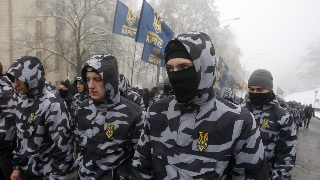 Vermummte Demonstranten nehmen an einem Protest vor dem ukrainischen Parlamentsgebäude teil.