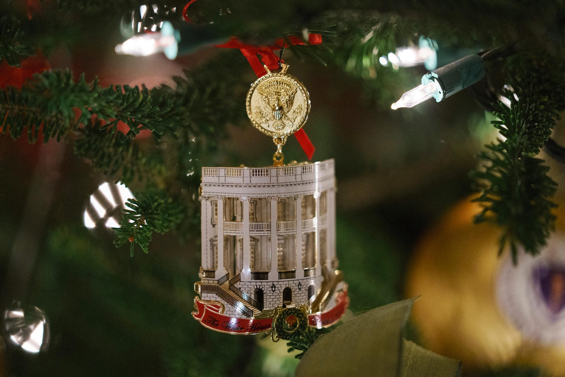 Das Weiße Haus als Weihnachtsanhänger mit dem Wappen des amerikanischen Präsidenten: Rund 14.000 rote Ornamente hängen an den Weihnachtsbäumen im Weißen Haus.