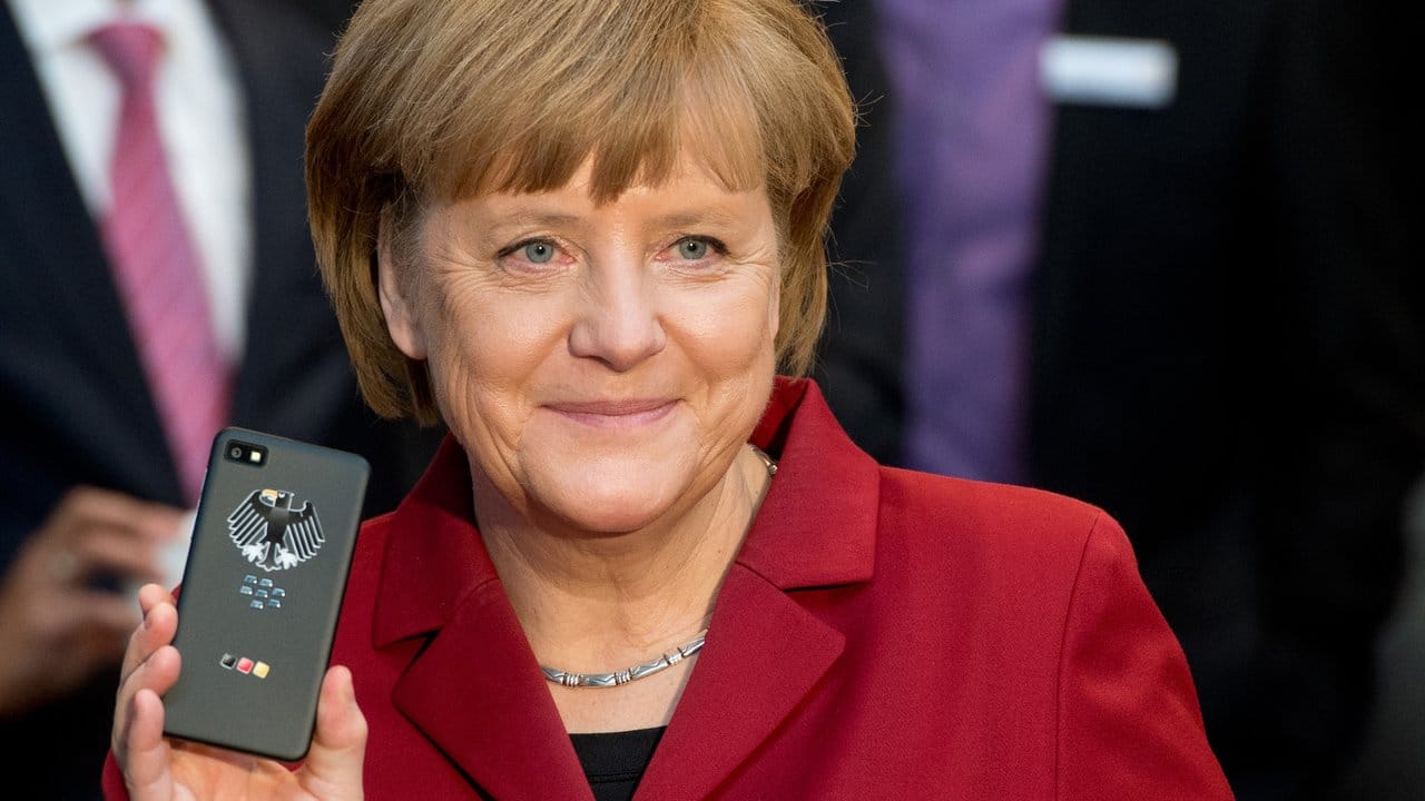 Cebit 2013: Bundeskanzlerin Angela Merkel (CDU) mit einem abhörsicheren Blackberry am Stand von Secusmart.