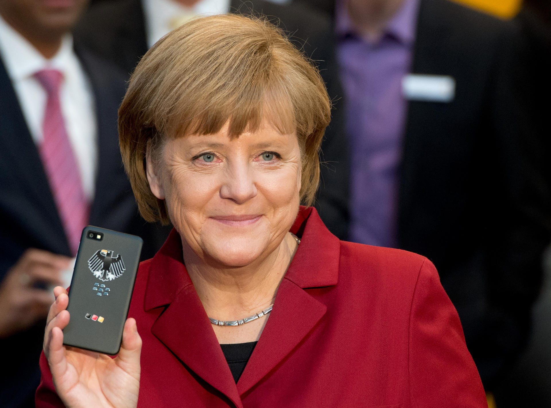 Cebit 2013: Bundeskanzlerin Angela Merkel (CDU) steht mit einem abhörsicheren Blackberry am Stand von Secusmart.