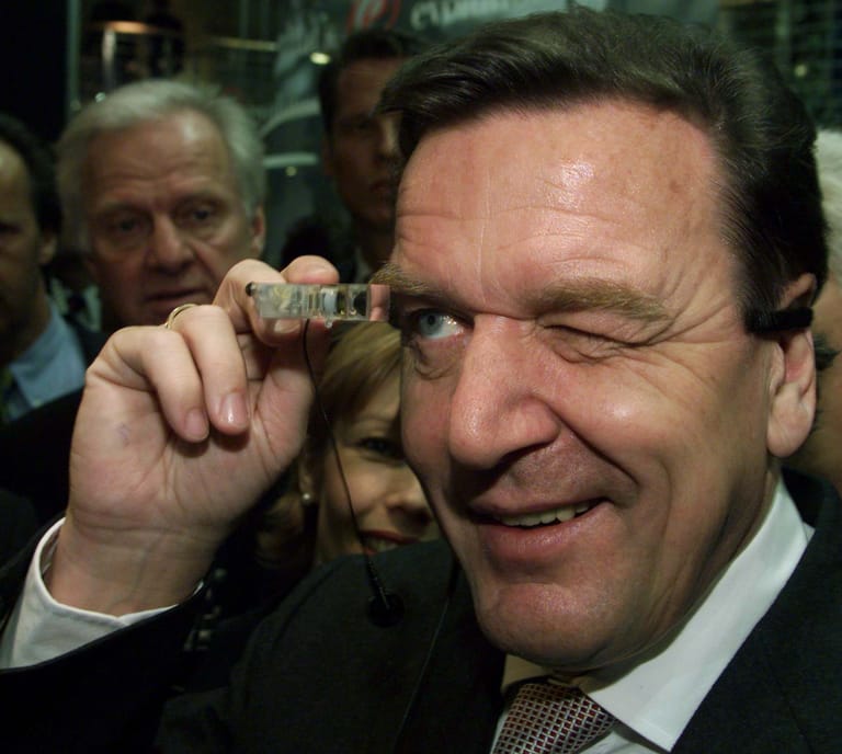 Der damalige Kanzler Gerhard Schröder mit einer tragbaren IBM-Gerät mit Minitor und Kopfhörern auf der Cebit 1999.