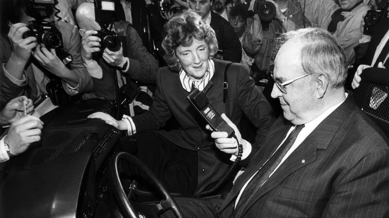 Umringt von Fotografen testet der damalige Bundeskanzler Helmut Kohl im Jahr 1989 bei der Cebit ein handliches Autotelefon.