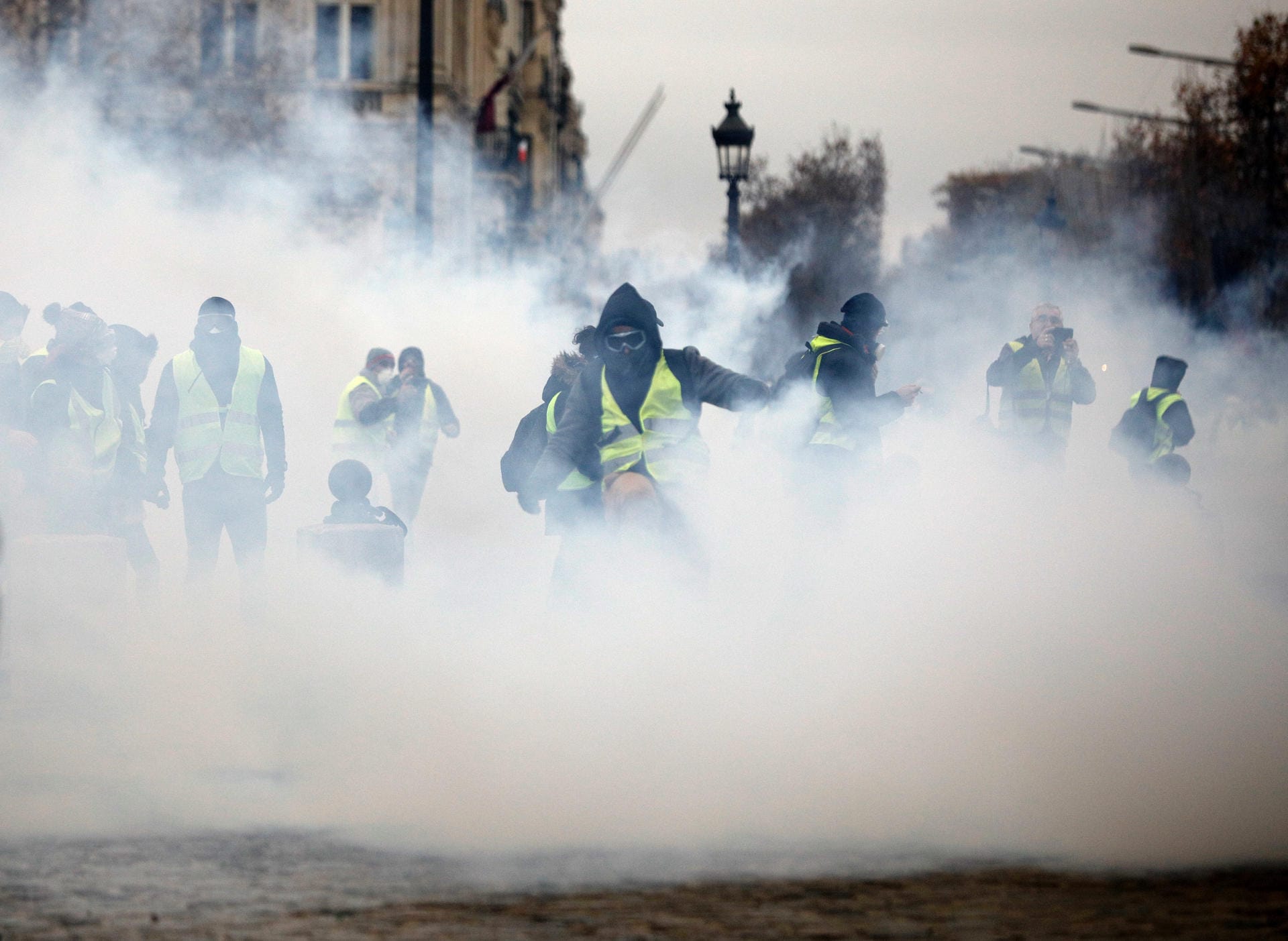 Die anhaltenden Auseinandersetzungen mit der Polizei hüllen die Pariser Prachtstraße Champs-Elysees und die Demonstranten in Wolken aus Tränengas.